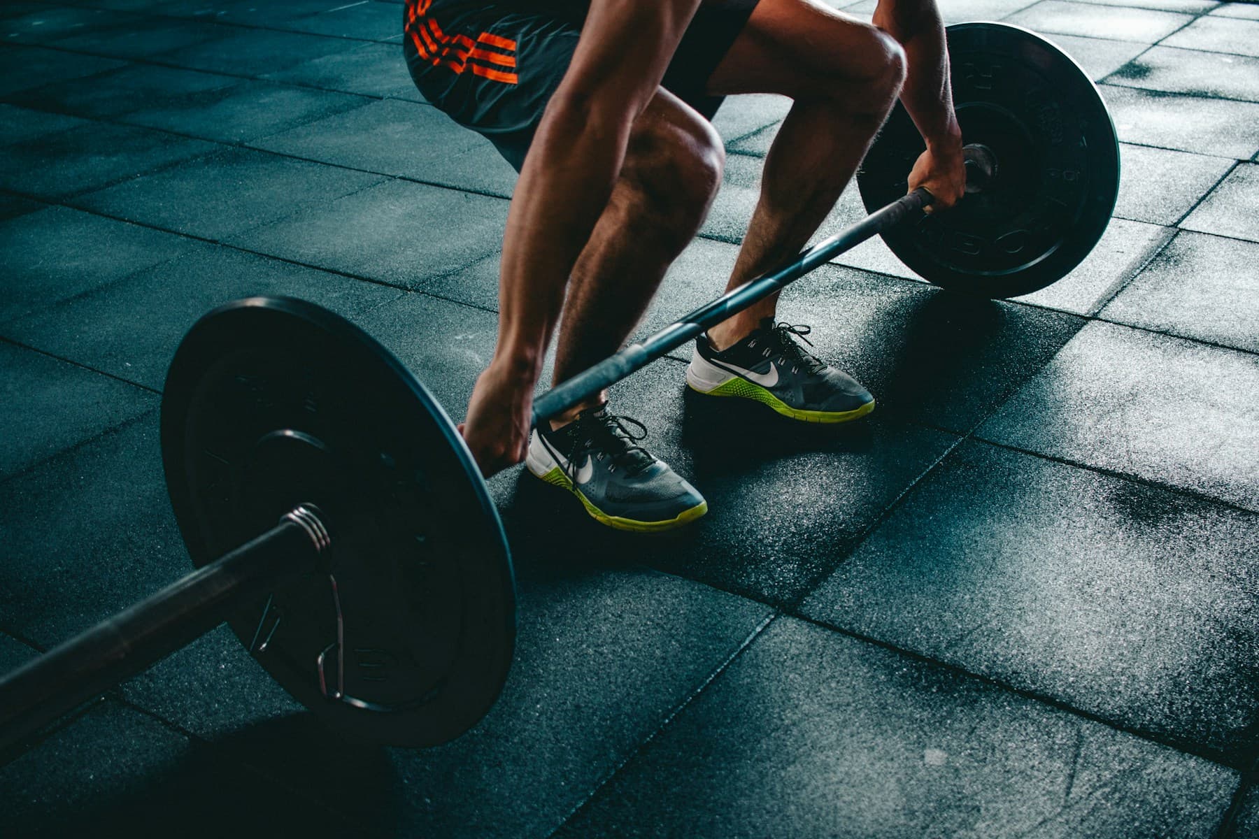 A person training with a barbell in a gym.